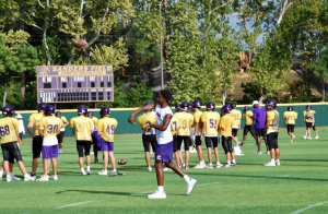 Wide receiver Folarin Oshe throws with a teammate during football practice on Sanders Field. 
